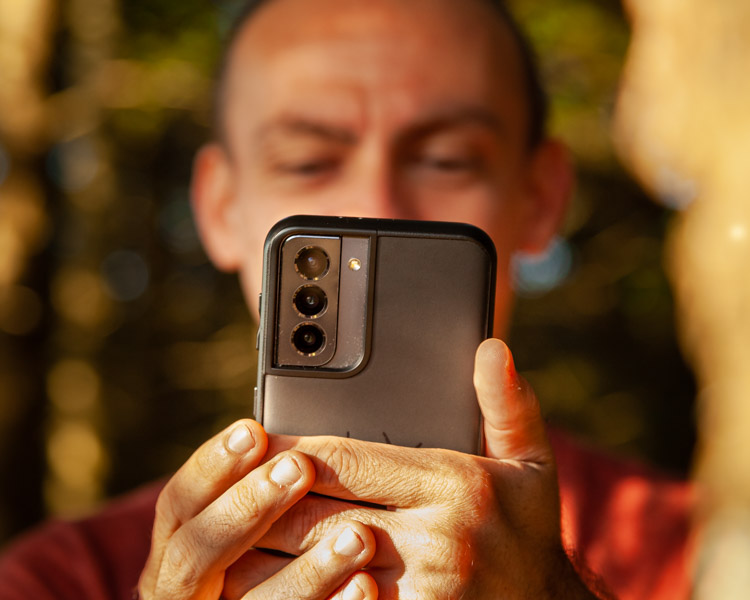 Xavier est concentré sur son smartphone pour une photo