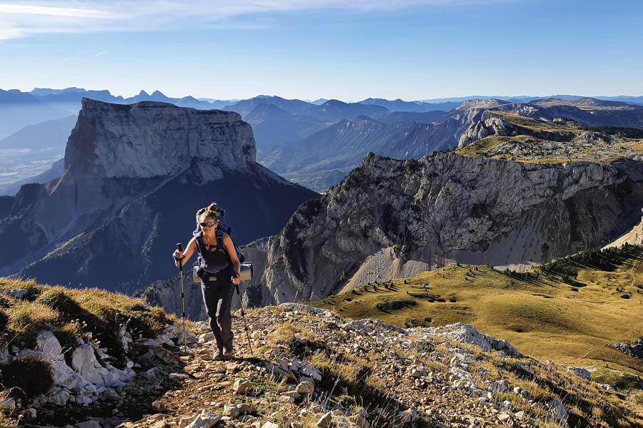 Une femme randonne dans le Vercors avec le mont Aiguille en fond
