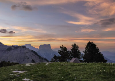 Tente de bivouac posée dans les Hauts Plateaux du Vercors, avec le Mont Aiguille et le magnifique ciel du coucher de soleil
